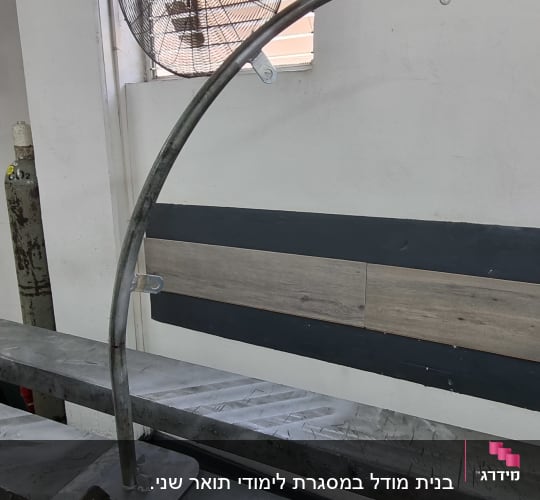 צינור מתכת מעוקל בתהליך ריתוך וייצור על שולחן עבודה במסגרייה